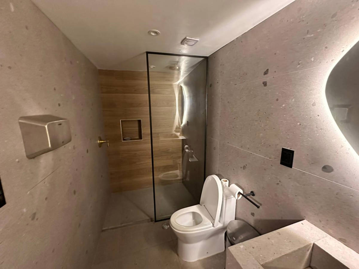 A toilet and shower inside the bathroom at the basement of Jaya Machu Picchu Boutique Hotel