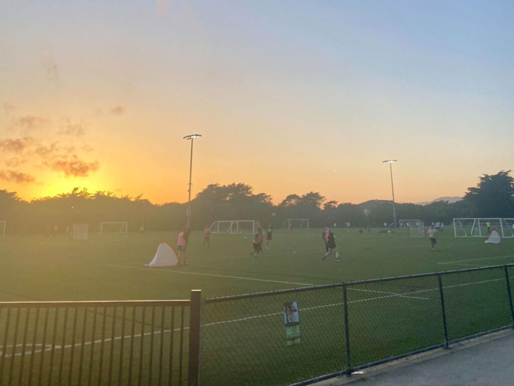 People playing at the Beach Chalet soccer fields during sunset