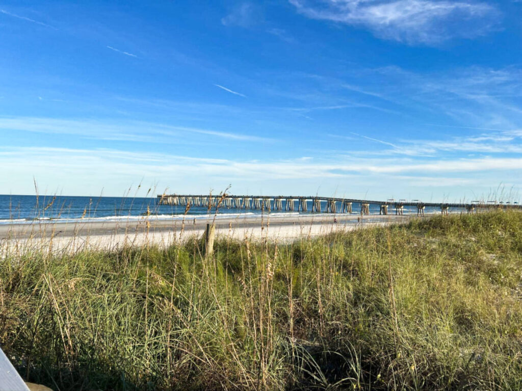 View of the long boardwalk and the Jacksonville Beach on a sunny day