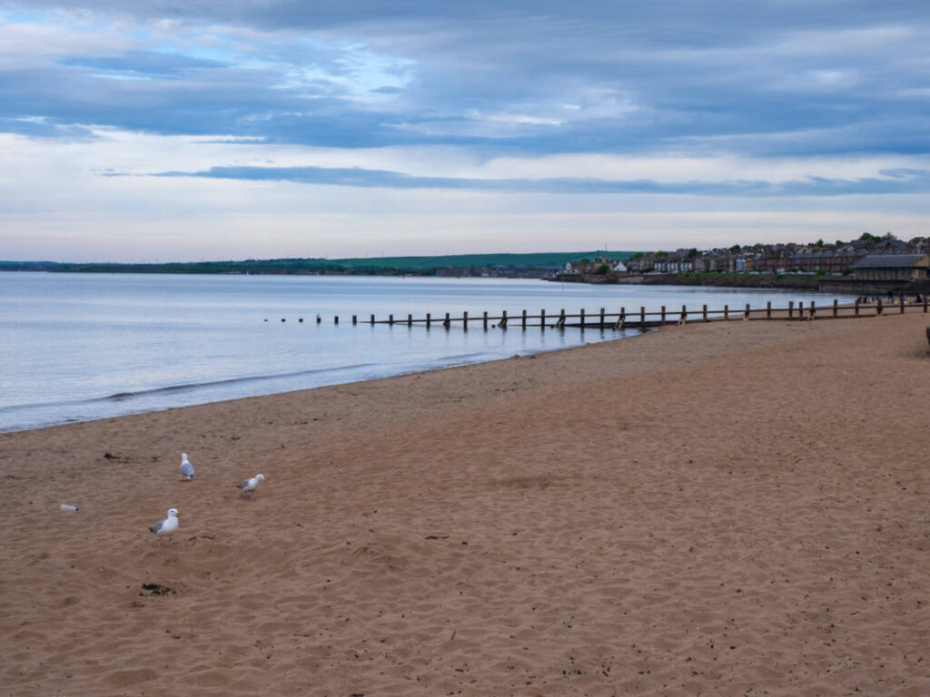 View of the vast shoreline and boardwalk in Portobello Beach