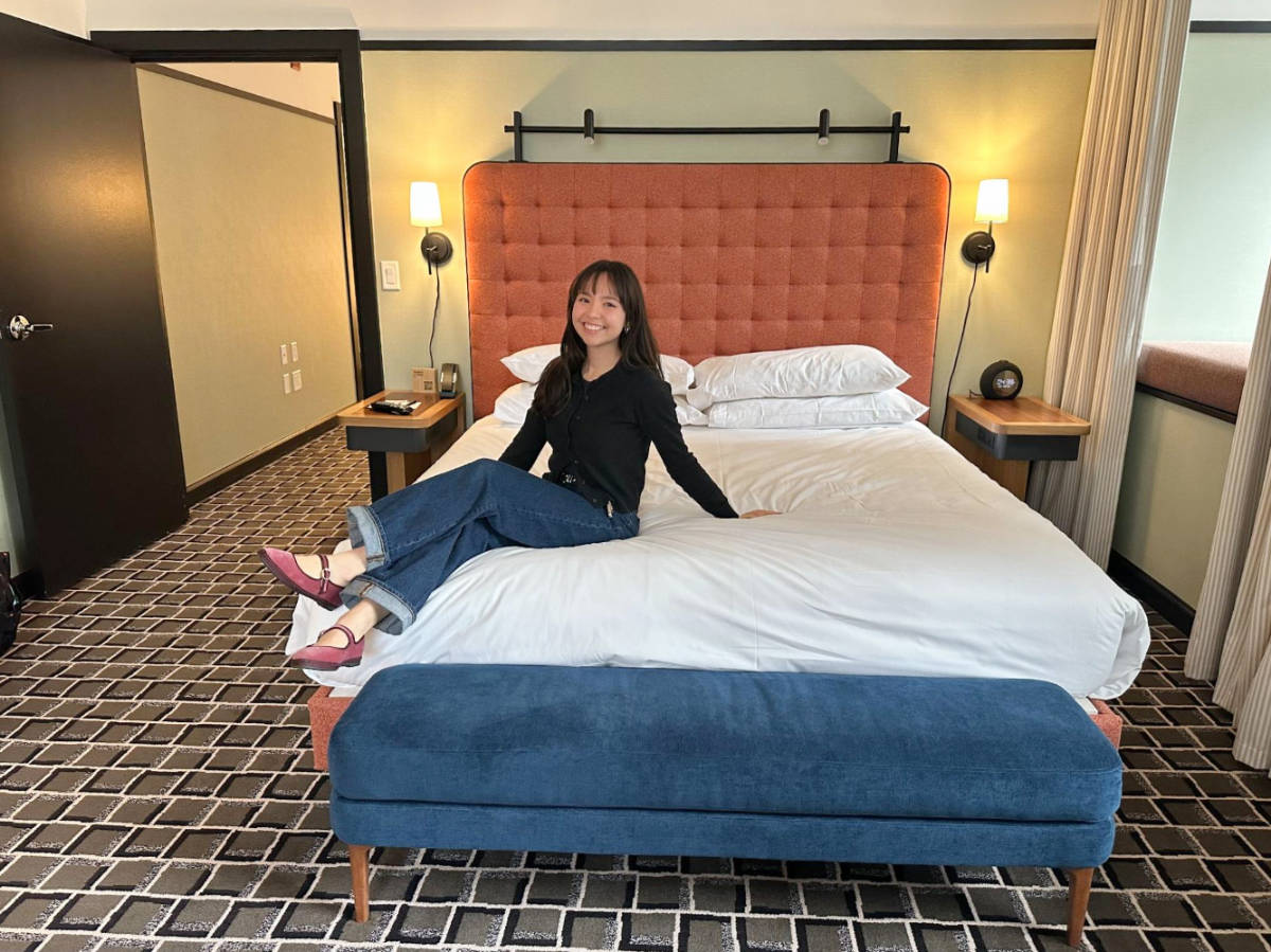 The author, Lea Rose Allbaugh sitting on her bed in L7 Chicago by Lotte