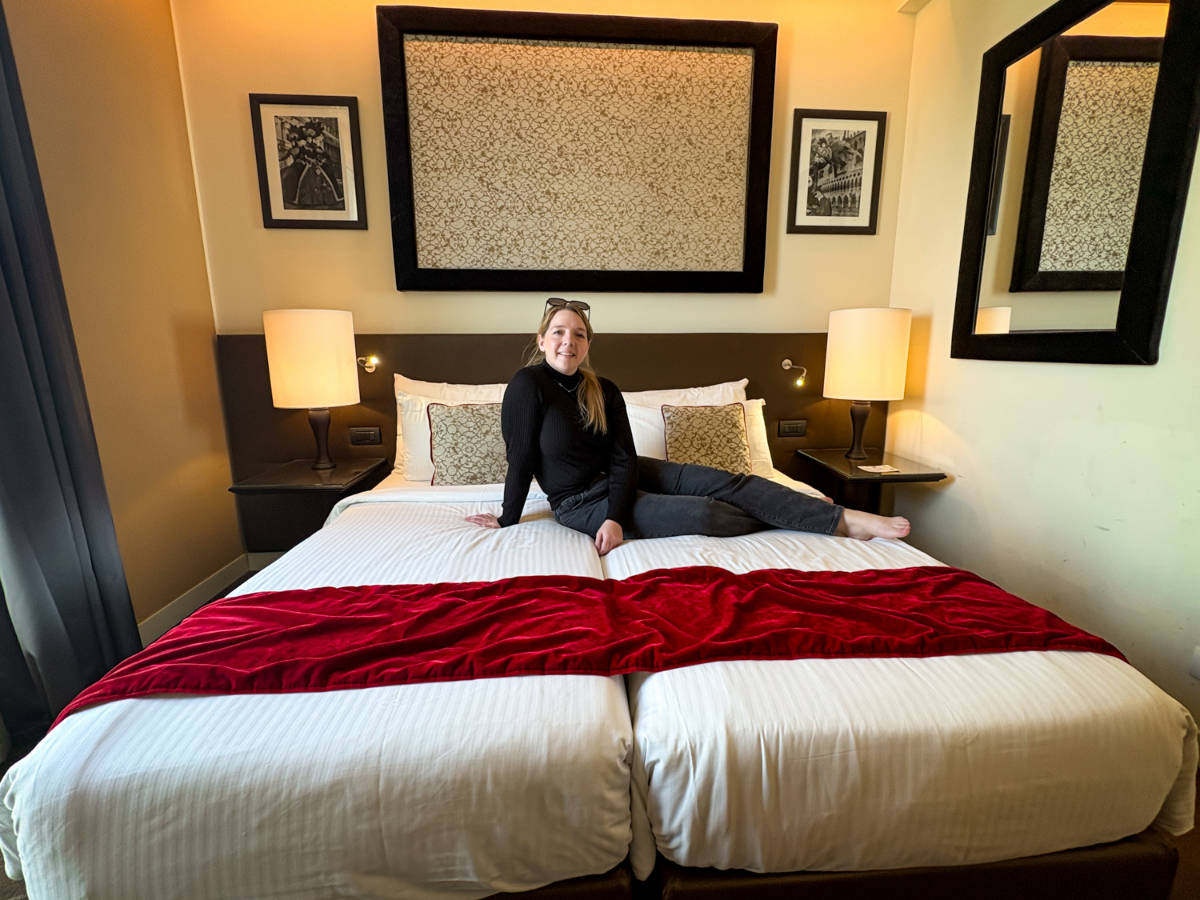 The author, Taylor Herperger sitting on her bed at Leonardo Royal Hotel