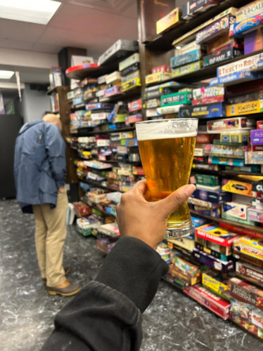 A hand holding a glass of beer at Ashleys Pub