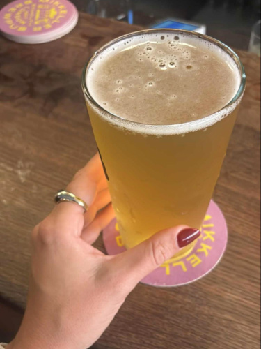 A hand holding a glass of craft beer