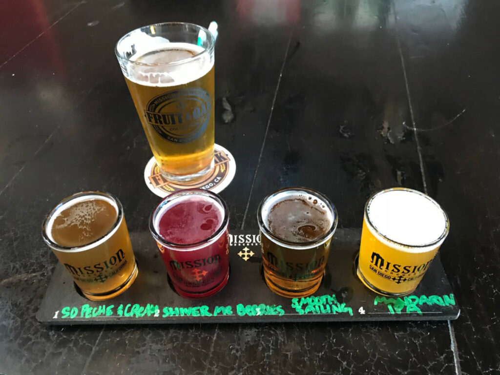 Beer flight with four sample glasses and one pint from Mission Brewery