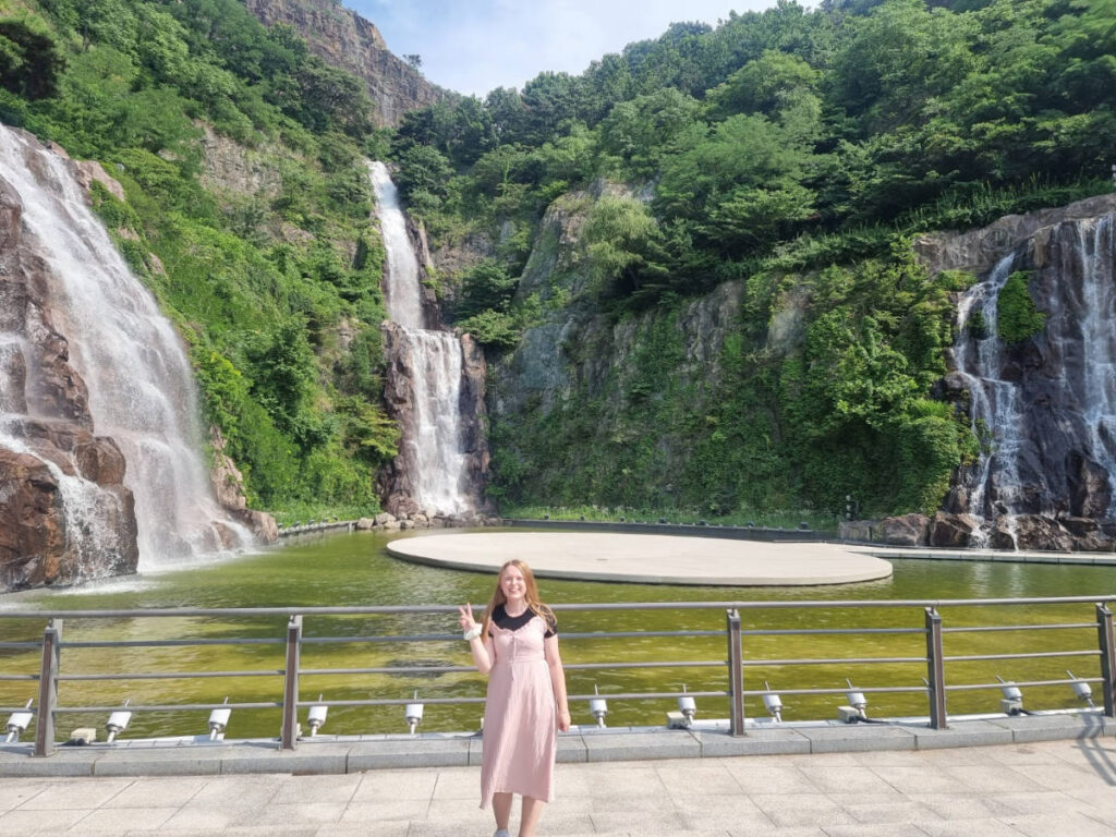 The author Bethan Nutting, smiling for a photo in front of Yongma Pokpo Falls