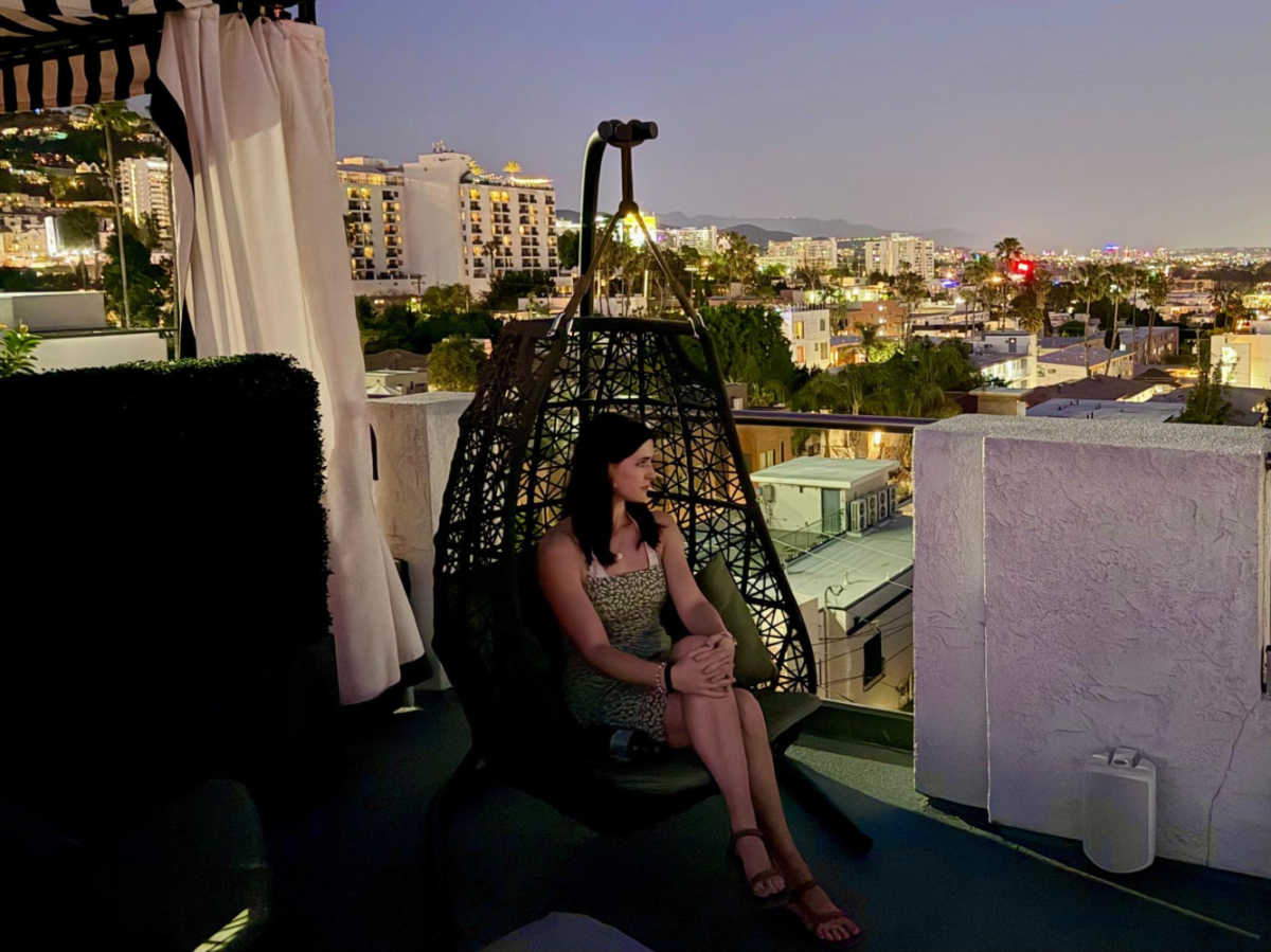 The author Betty Hurd enjoying the city lights in an egg chair by the pool at dusk
