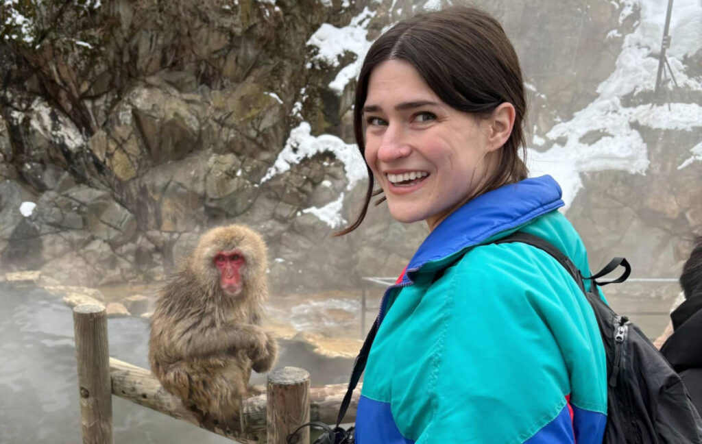 The author, Betty Hurd smiling for a photo with a Japanese snow monkey