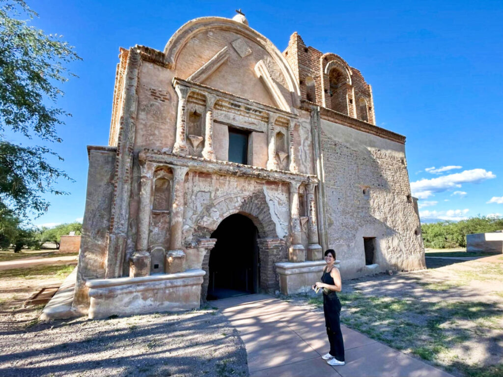 The author Betty Hurd, posing in front of the Tubac and Tumacacori National Historical Park