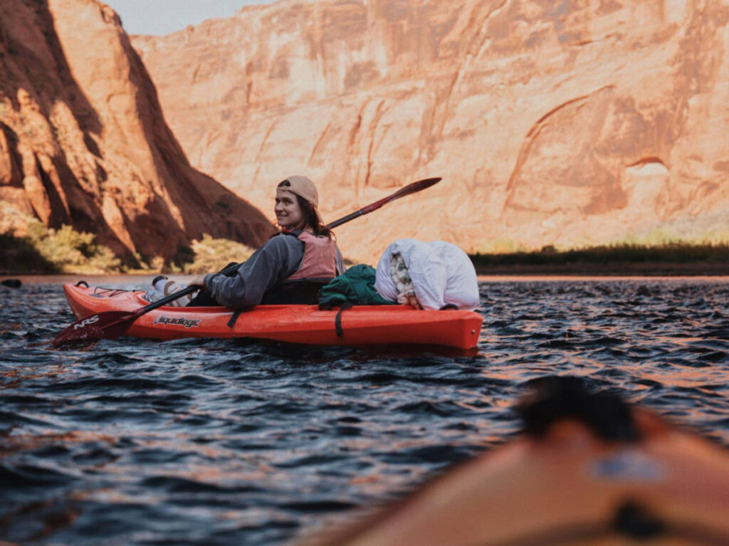 The author Betty Hurd smiling for a photo while kayaking on a river