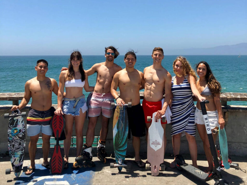 Travel Lemming writer, Betty Hurd and her friends holding longboards from the main Venice boardwalk