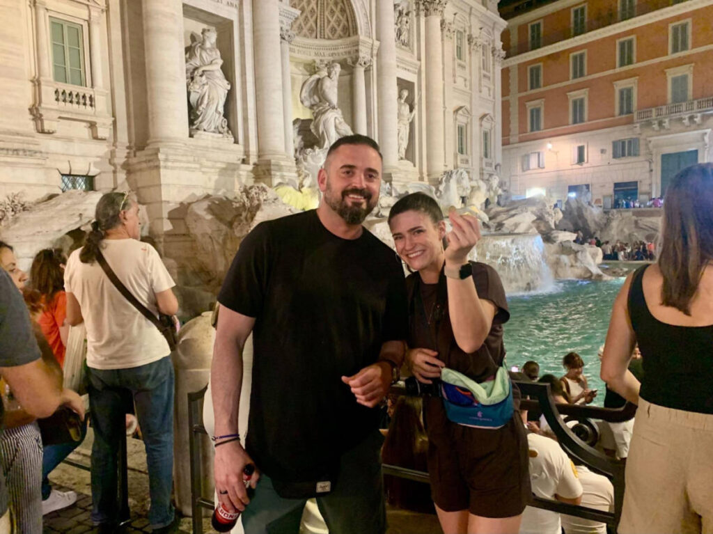 The author Betty Hurd and her friend, tossing her coin at the crowded Trevi Fountain at night