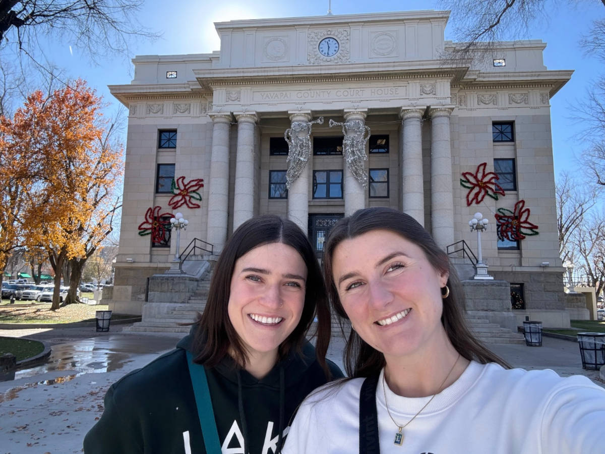 The author Betty Hurd with her best friend smiling for a photo in front of a courthouse in Downtown Prescott