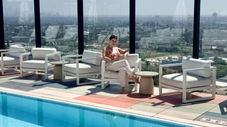 Travel Lemming writer, Betty Hurd, sitting on the lounge chair at the poolside in Sun Rose Hotel