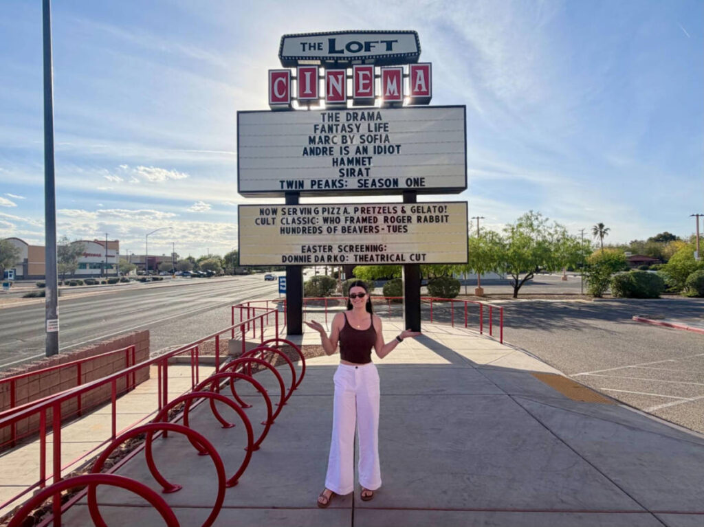 The author Betty Hurd, posing for a photo in front of the signage of  The Loft