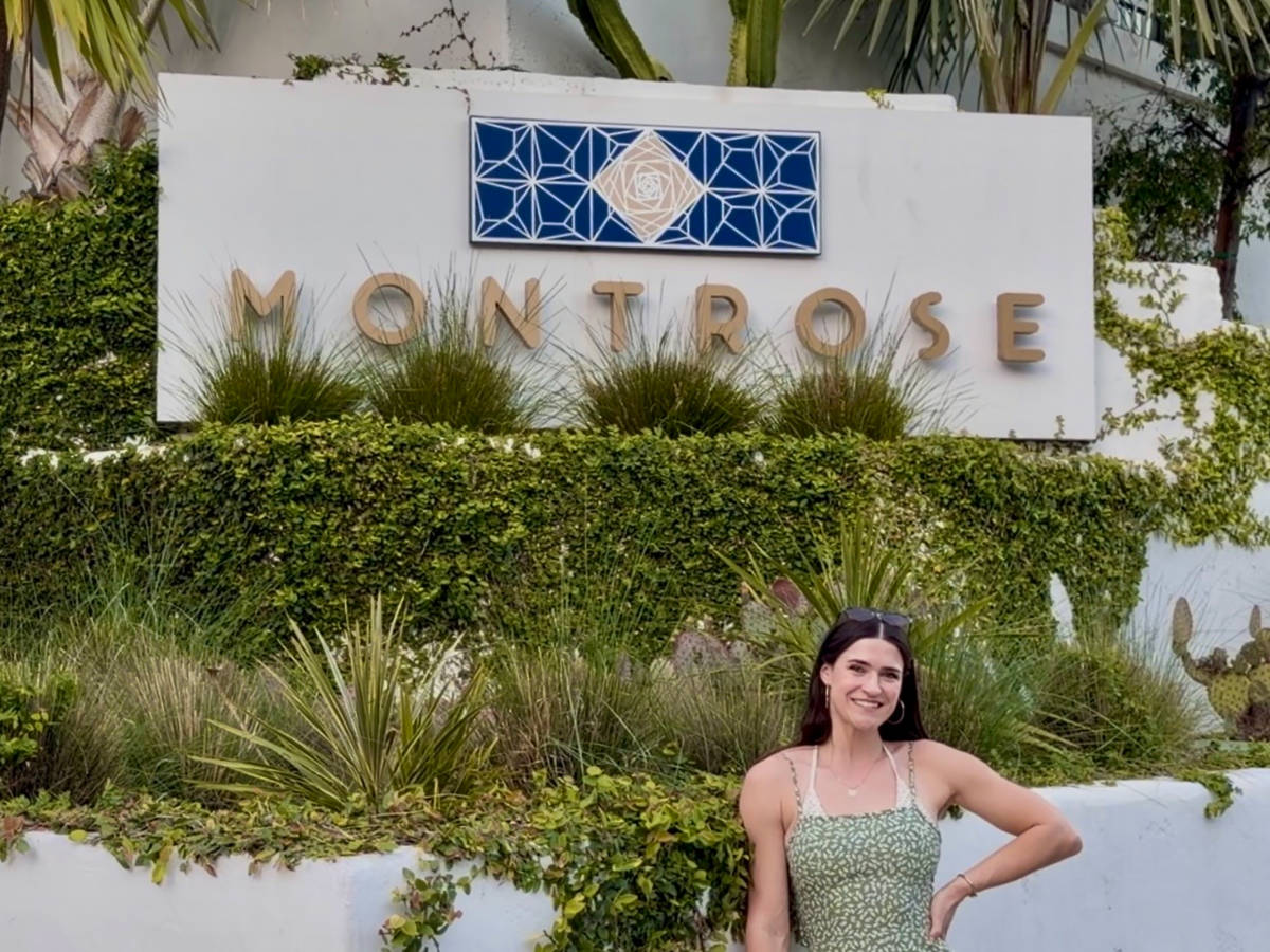 The author Betty Hurd smiling for a photo in front of the Montrose sign