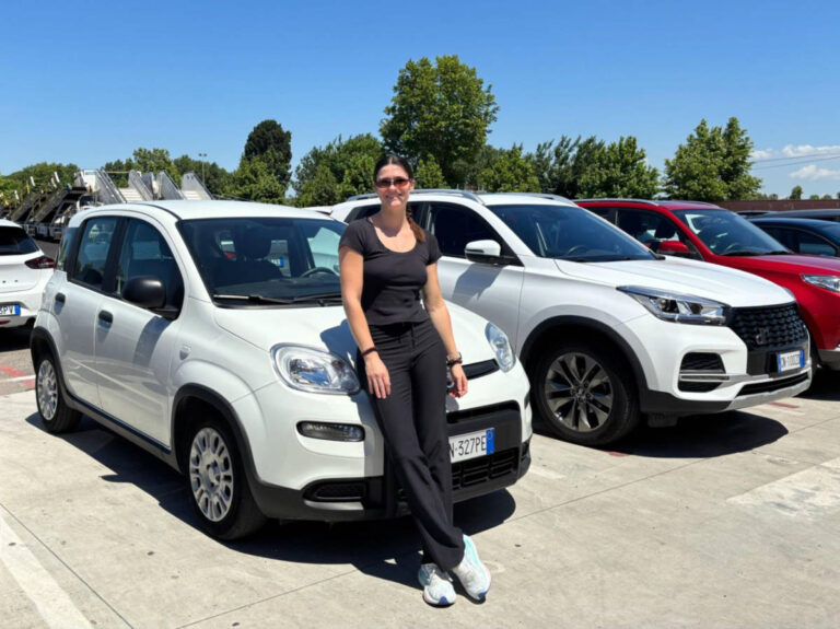 The author Betty Hurd, leaning o the Opel Corsa car