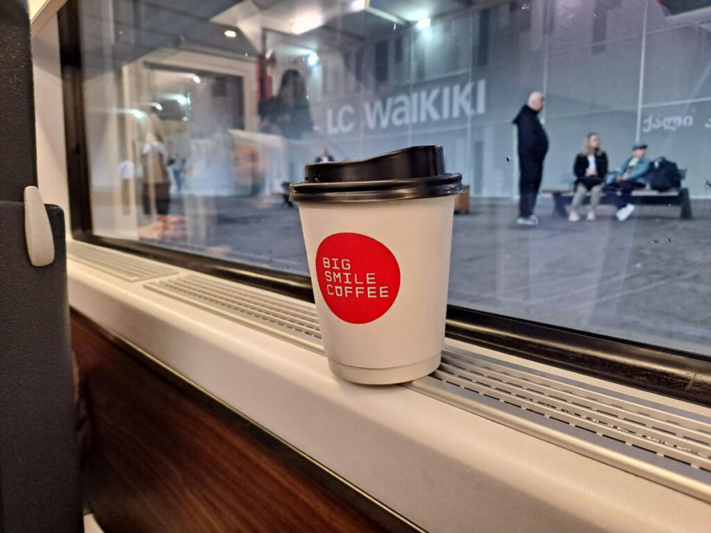 A cup of coffee on a train in Big Smile Coffee