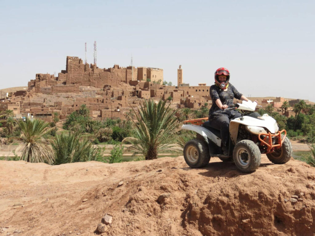 The author Heather Cole, riding an ATV around the Fortress of Ait Ben Haddou