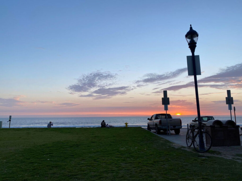 Sunset view in Carlsbad with a view of the grass field, parked cars and bikes