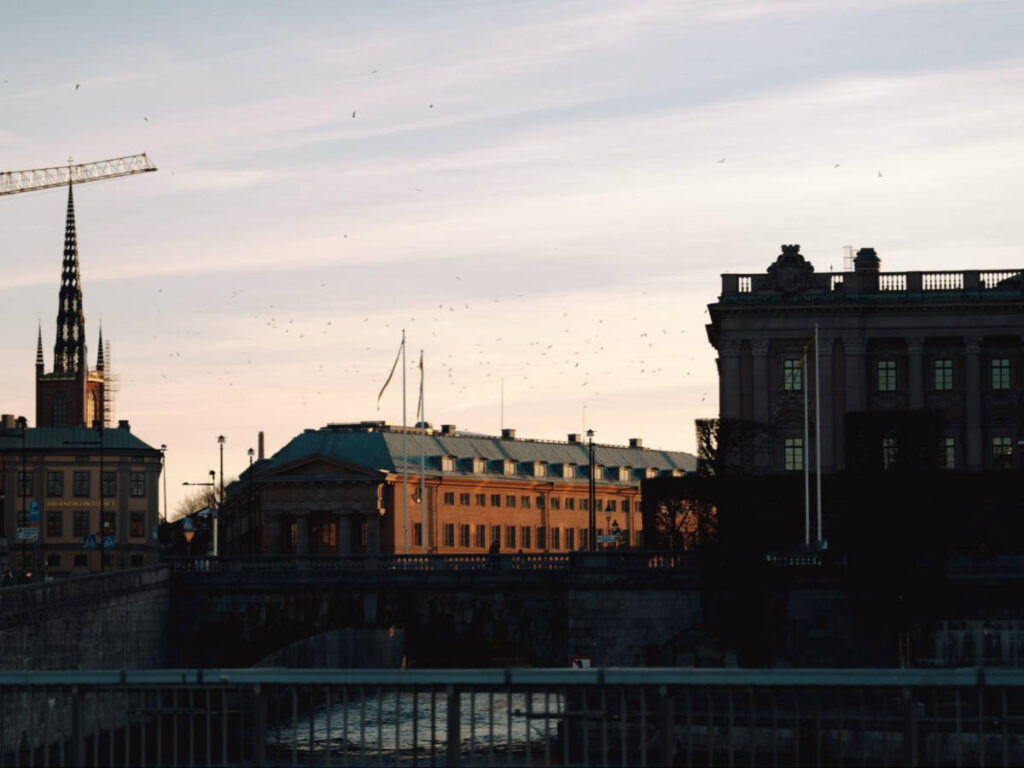Scenic view of the birds flying over Gamla Stan at sunset
