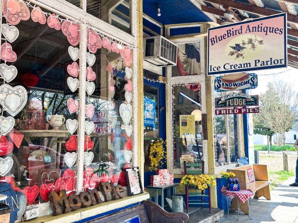 View of the Valentine’s Day decor on the glass window of BlueBird Antiques & Ice Cream Parlor