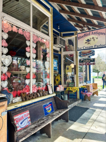 View of the Valentine’s Day decor on the glass window of BlueBird Antiques & Ice Cream Parlor