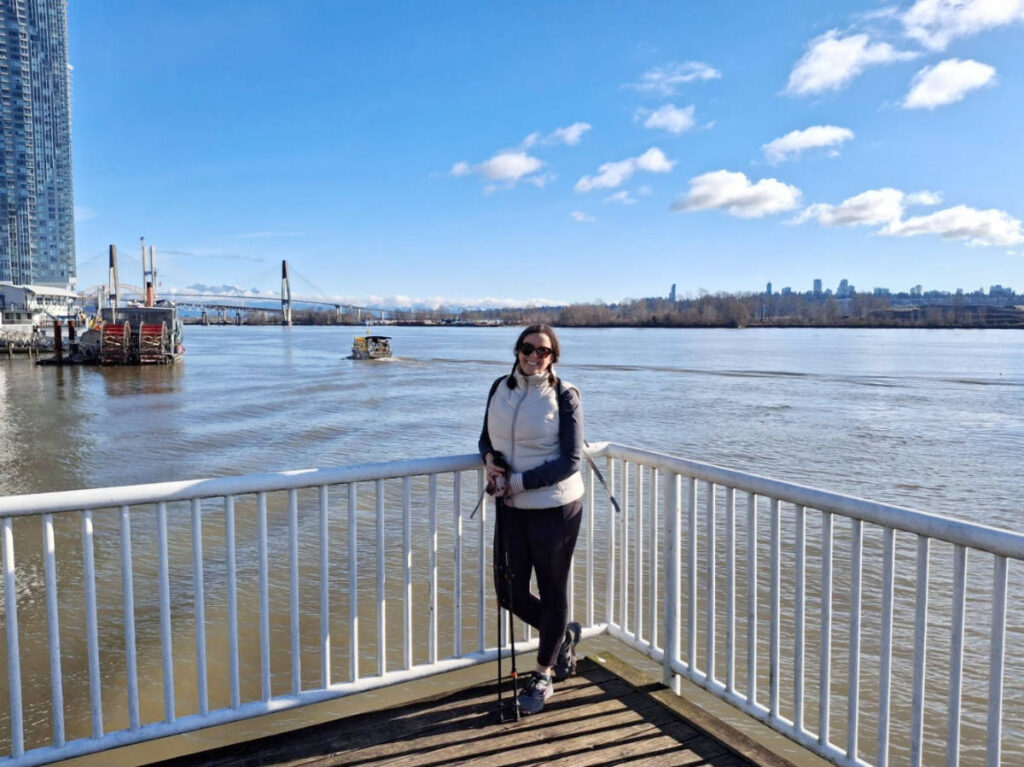 The author, Catherine Driver smiling for a photo on the boardwalk at the Fraser River