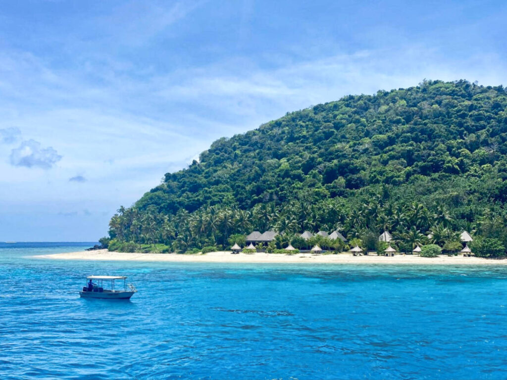 View of the small huts on the island with a boat nearby