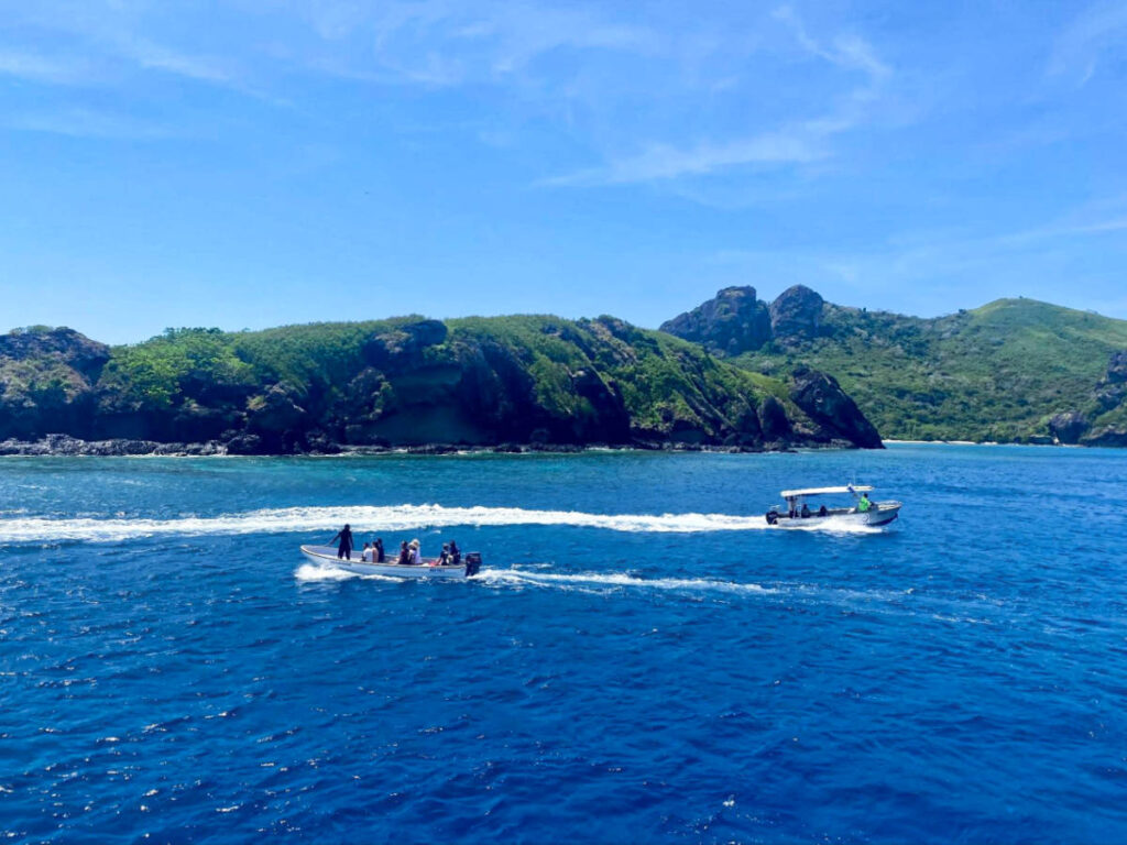 Tourists boating with the lush islands around