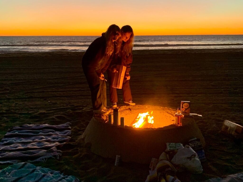 Two ladies setting up the bonfire at Dockweiler State Beach during sunset