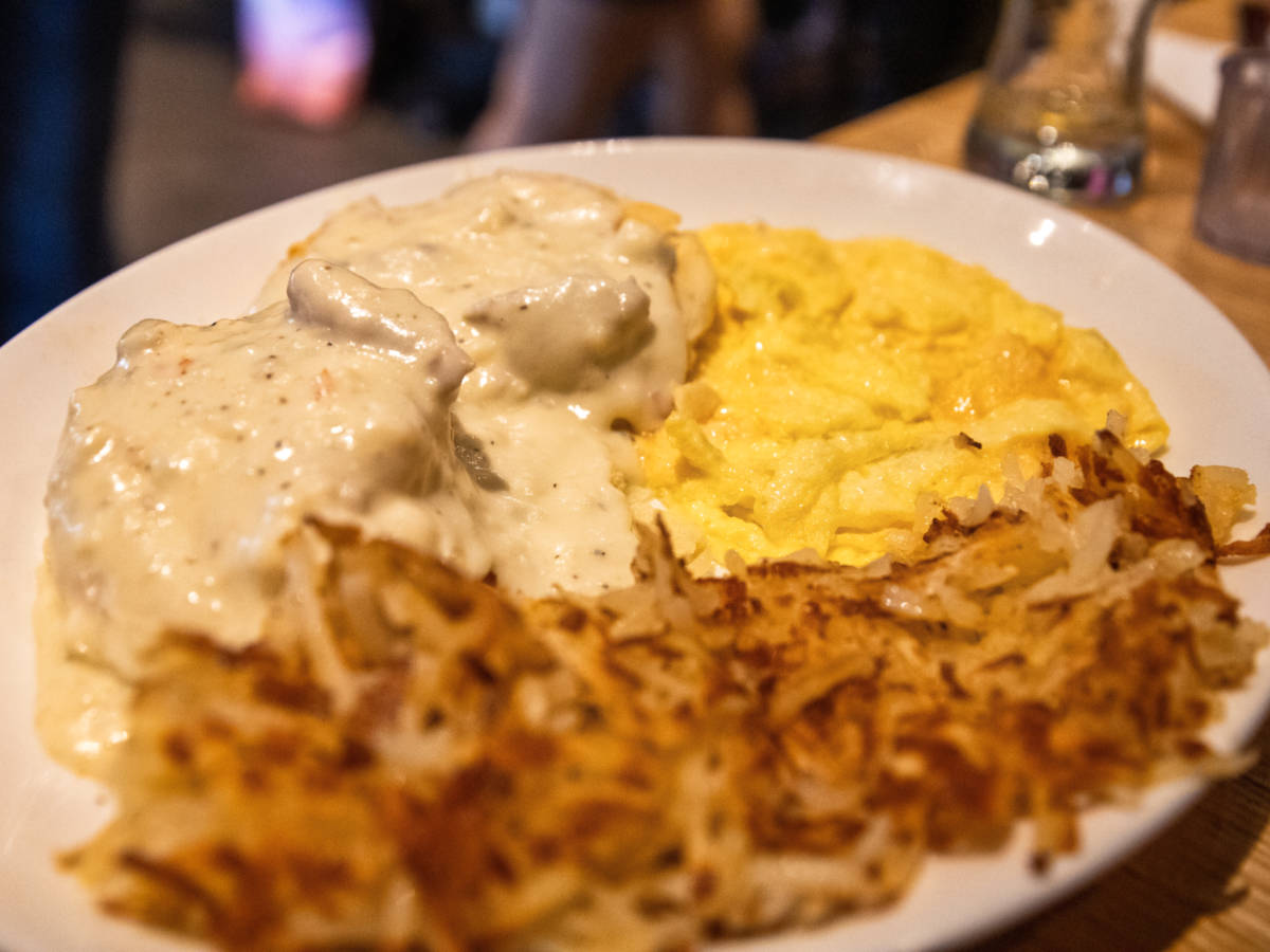 Closeup look of a plate with scrambled eggs breakfast with biscuits and gravy