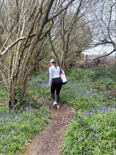 The author Brooke Horrobin, walking along the trail surrounded by wild flowers along Leigh Hill