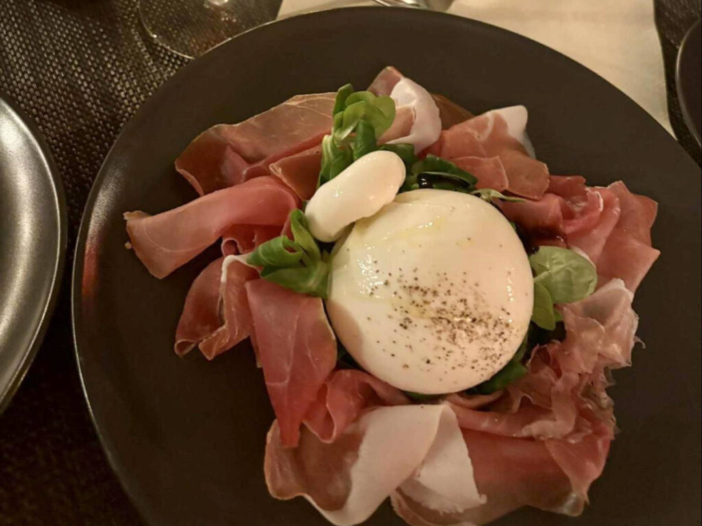 A plate of burrata and prosciutto at Perbacco