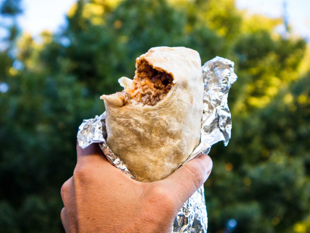 A hand holding a burrito