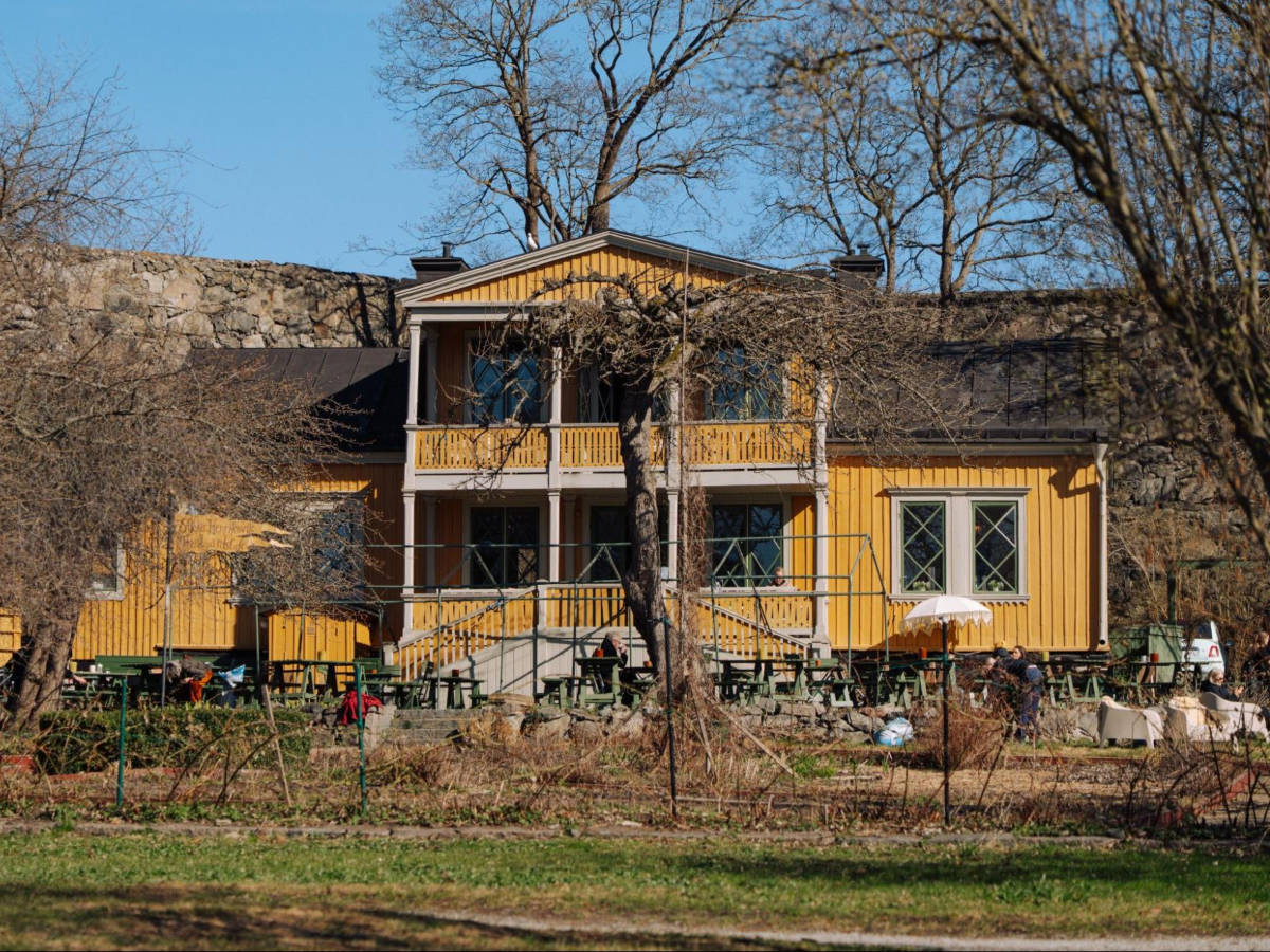 A vibrant yellow exterior of Café Stora Henriksvik