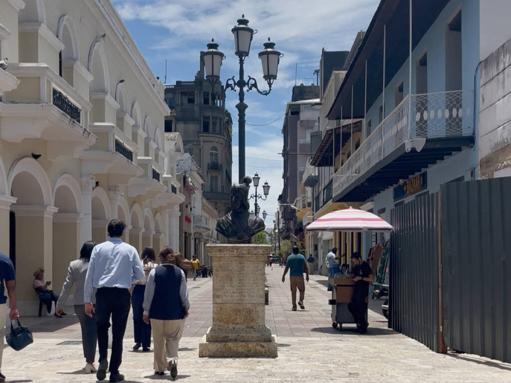 People walking along Calle el Conde on a sunny morning