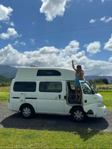 Author's partner posing with the campervan after arrival