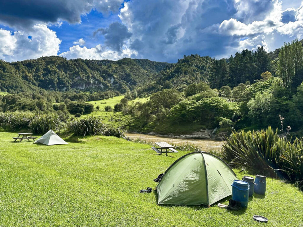 A camping tent along the Whanganui River surrounded by greenery