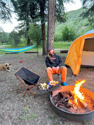 The authors husband sitting in front of the fireplace at the campground near Paonia