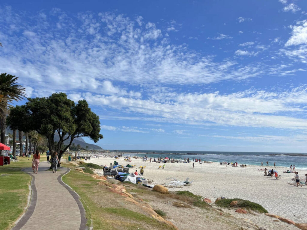 People relaxing along the scenic shoreline of Camps Bay Beach