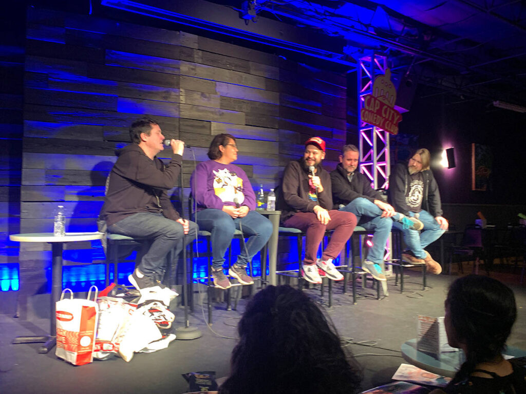 A panel of comedians at the stage of Cap City Comedy Club