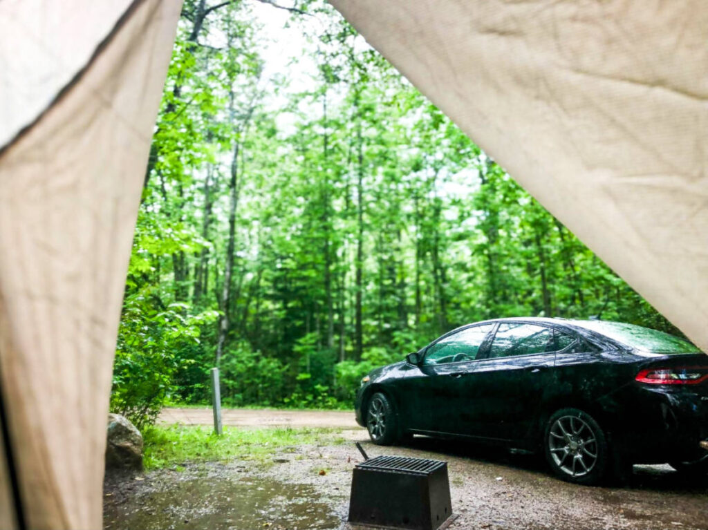A car parked outside the camping tent