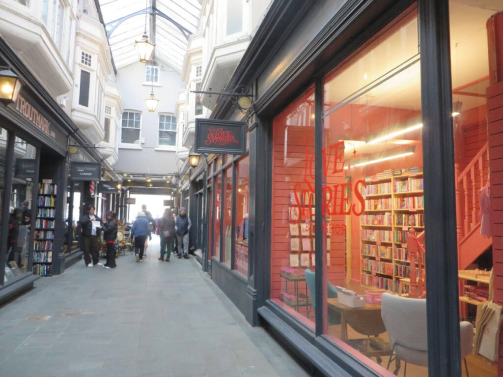 View of the Love Stories bookstore and other shops along the arcade in Cardiff
