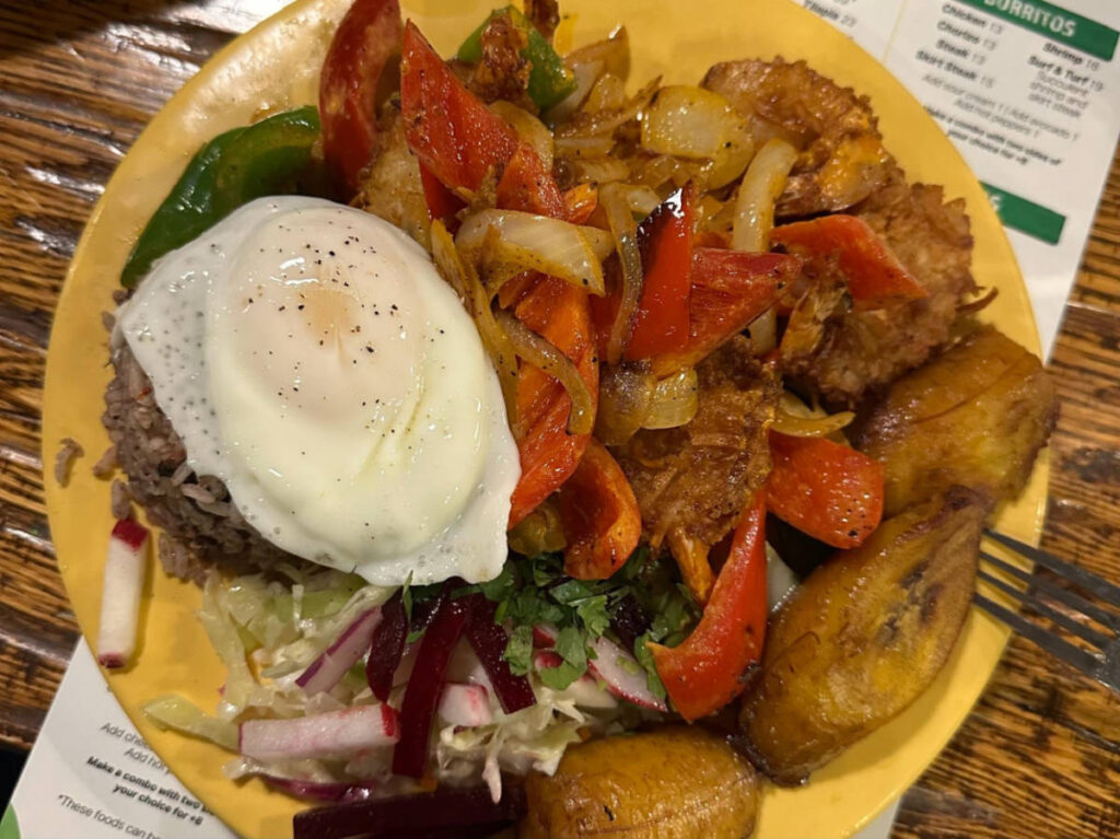 A plate of casado with chicken topped with egg from Irazu 
