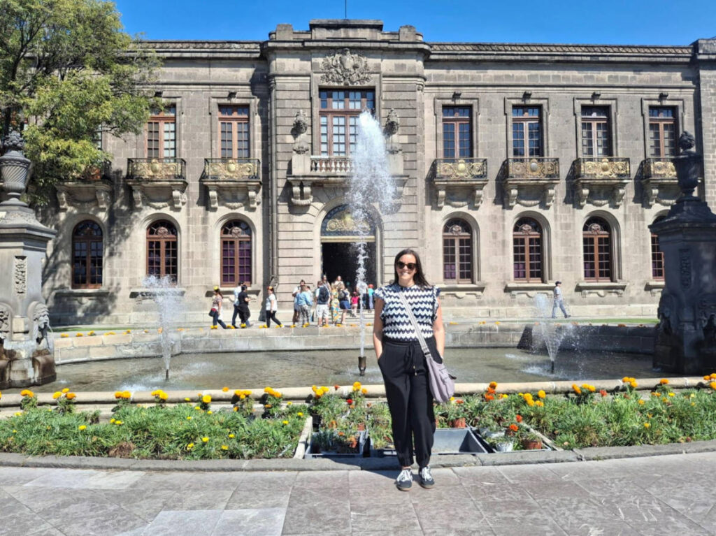 Travel Lemming writer Catherine Driver, posing in front of the fountain surrounded by marigolds at Chapultepec Castle