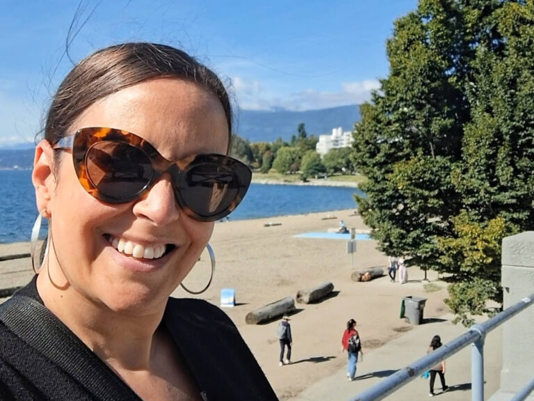 The author Catherine Driver, smiling for a photo at the English Bay on a sunny day
