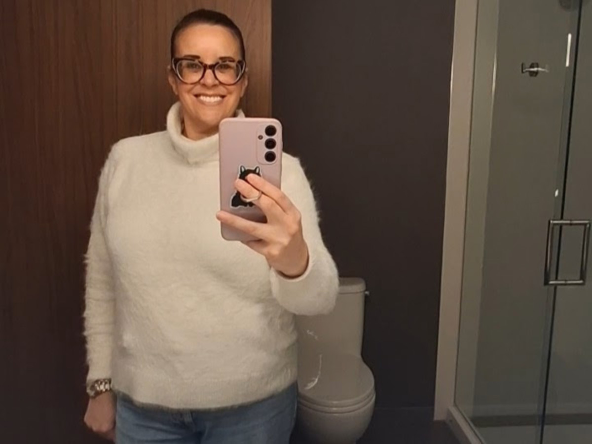 The author Catherine Driver, smiling while taking a photo from the mirror