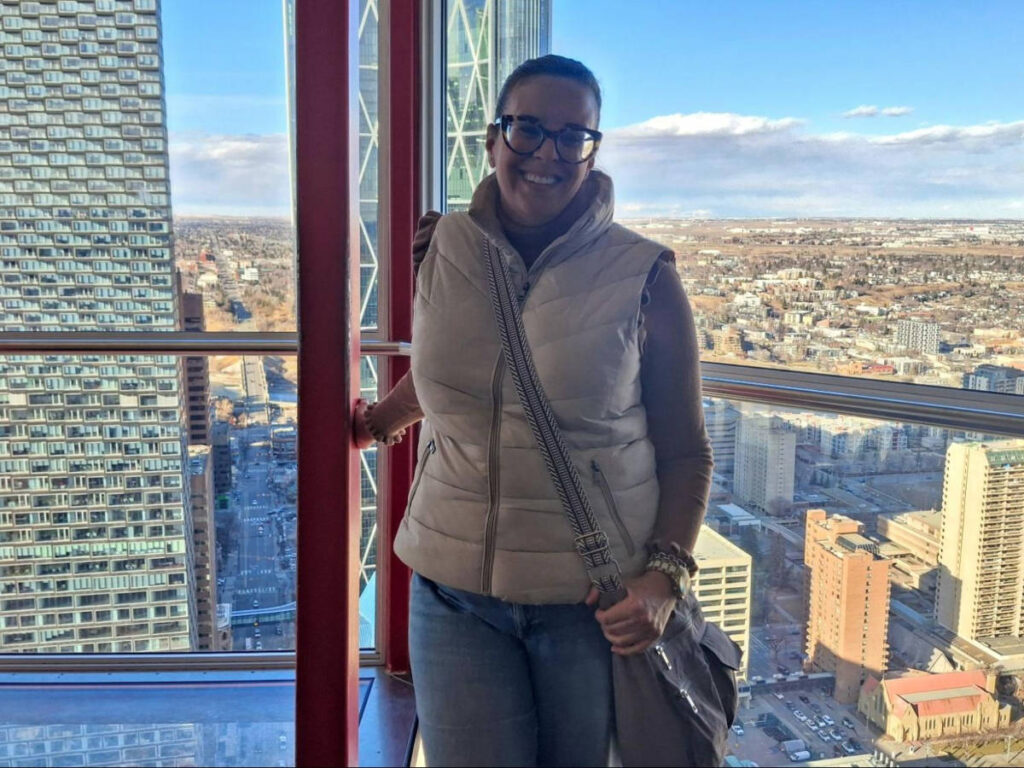 The author Catherine Driver, holding the railing at the Calgary Tower