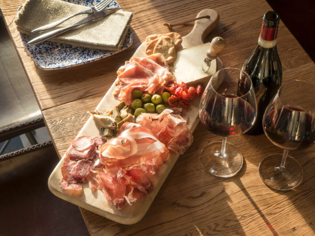 Charcuterie platter with a variety of meat and cheese and wine at Tibble and Ramble